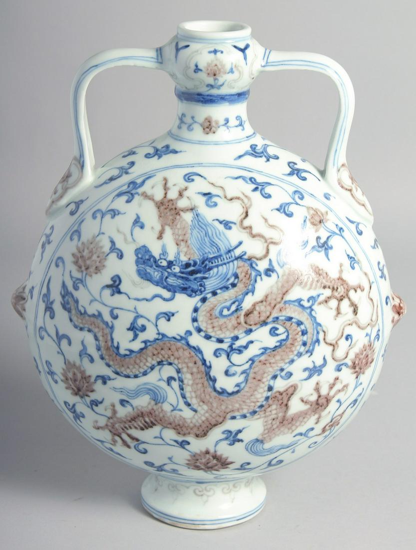 A CHINESE BLUE, WHITE, AND UNDERGLAZE RED TWIN HANDLED MOON FLASK painted with dragon and lotus, the (1 of 7)