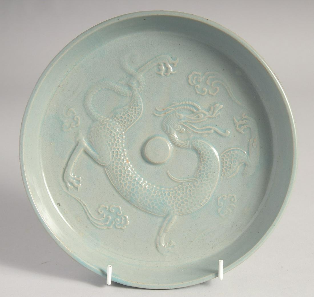 A CHINESE CELADON DRAGON DISH, 21cm diameter.: A CHINESE CELADON DRAGON DISH, 21cm diameter.