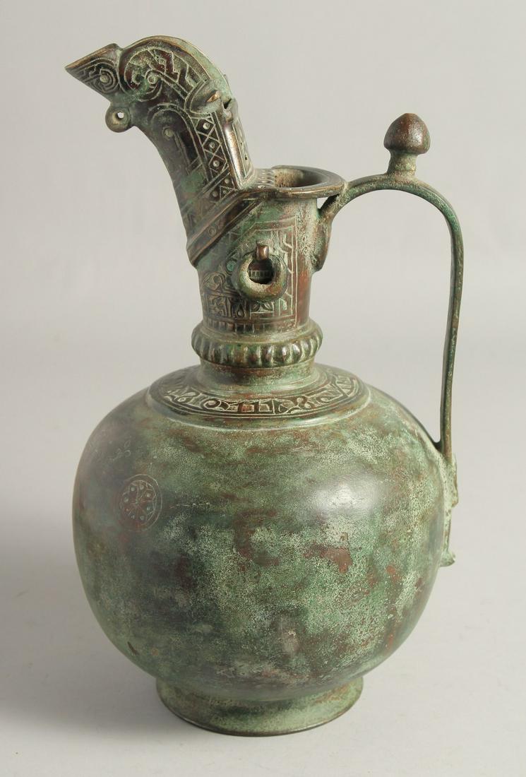 A LARGE SELJUK STYLE BRONZE EWER, with engraved decoration to the neck and spout, drop rings, and (1 of 6)