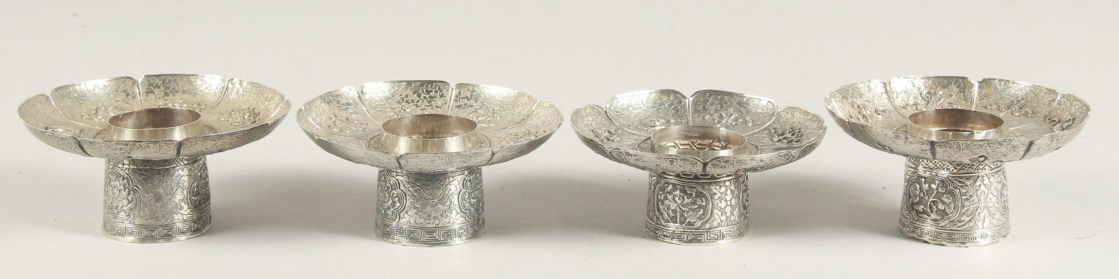 A SET OF FOUR CHINESE SILVER PEDESTAL DISHES, with engraved decoration and precious objects in (1 of 3)