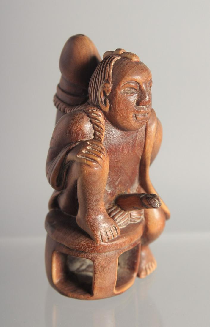 AN EROTIC CARVED WOOD NETSUKE. 2.25ins: AN EROTIC CARVED WOOD NETSUKE. 2.25ins