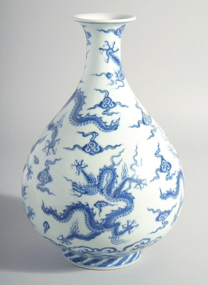 A CHINESE MING STYLE BLUE AND WHITE PORCELAIN YUHUCHUN BOTTLE VASE, painted with dragons and: A CHINESE MING STYLE BLUE AND WHITE PORCELAIN YUHUCHUN BOTTLE VASE, painted with dragons and stylised clouds, six-character mark to base, 27cm high.