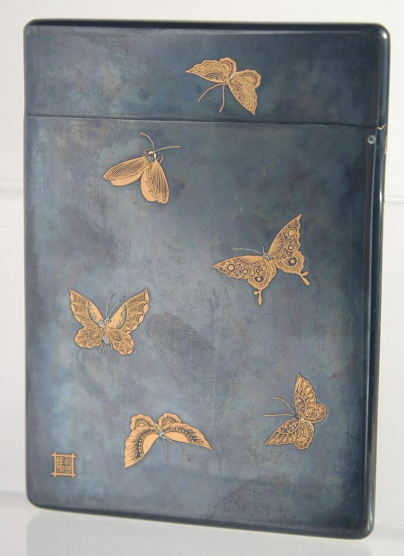 A JAPANESE MEIJI PERIOD SHAKUDO, GOLD AND SILVER INLAID CARD CASE, signed S. Komai, finely decorated: A JAPANESE MEIJI PERIOD SHAKUDO, GOLD AND SILVER INLAID CARD CASE, signed S. Komai, finely decorated with a female figure playing a musical instrument and butterflies, closing mechanism in good workin