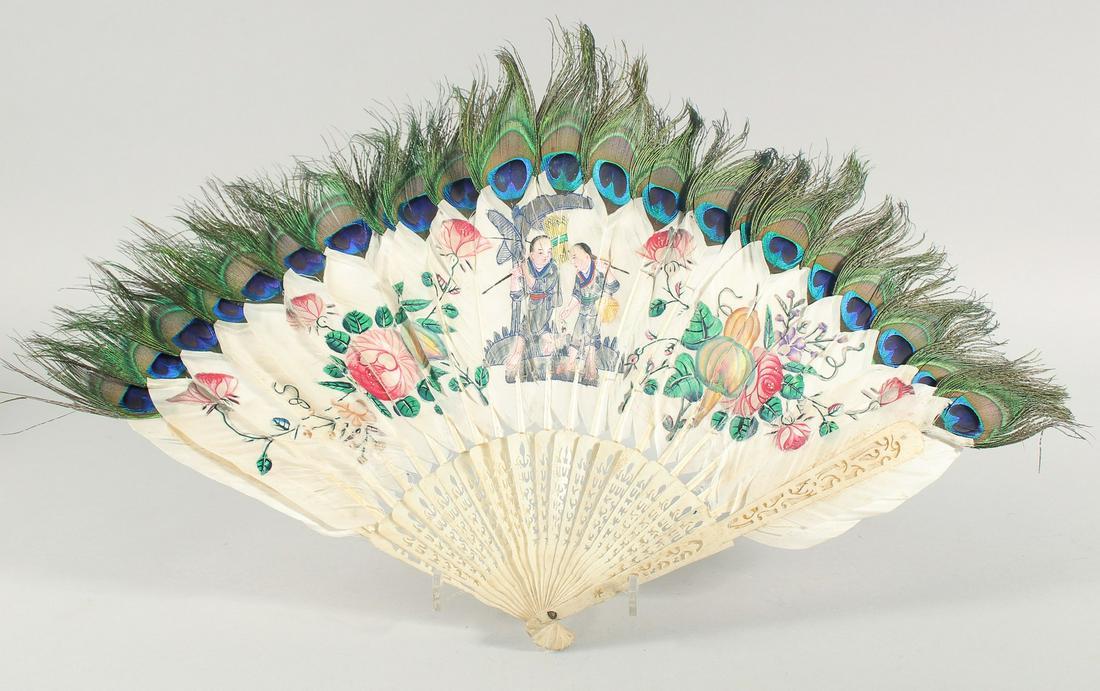 A CHINESE CANTON CARVED AND PIERCED BONE FAN, with peacock feathers.: A CHINESE CANTON CARVED AND PIERCED BONE FAN, with peacock feathers.
