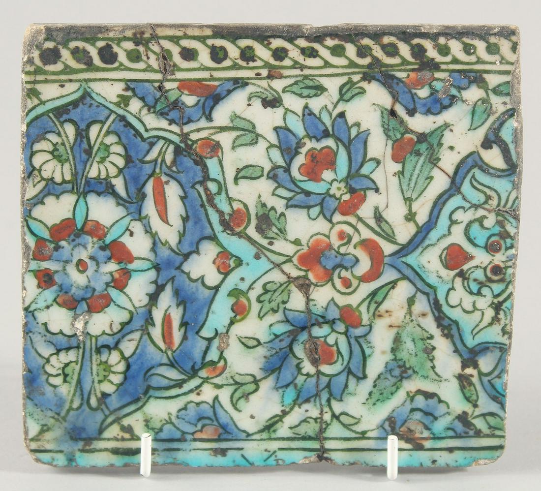A 18TH/19TH CENTURY IZNIK GLAZED POTTERY TILE, decorated with foliate motifs in blue, turquoise and: A 18TH/19TH CENTURY IZNIK GLAZED POTTERY TILE, decorated with foliate motifs in blue, turquoise and red, 15cm x 16.5cm.