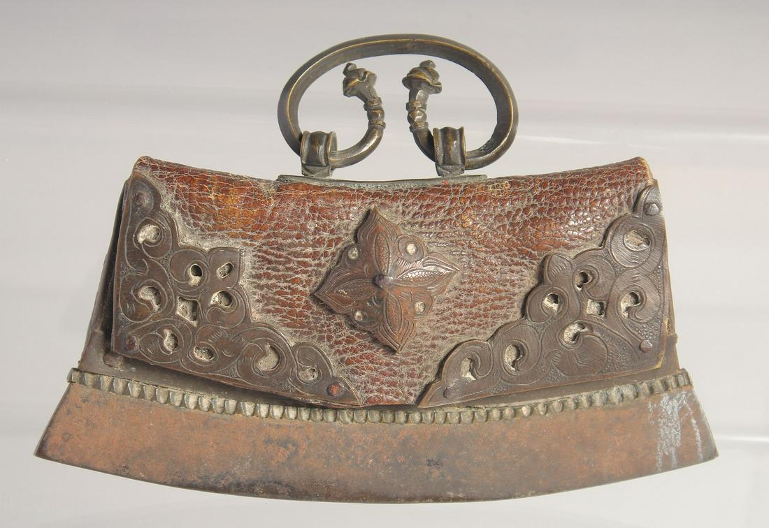 A TIBETAN MECHA FIRE STRIKER, with leather pouch and metal mounts, 12.5cm wide.: A TIBETAN MECHA FIRE STRIKER, with leather pouch and metal mounts, 12.5cm wide.