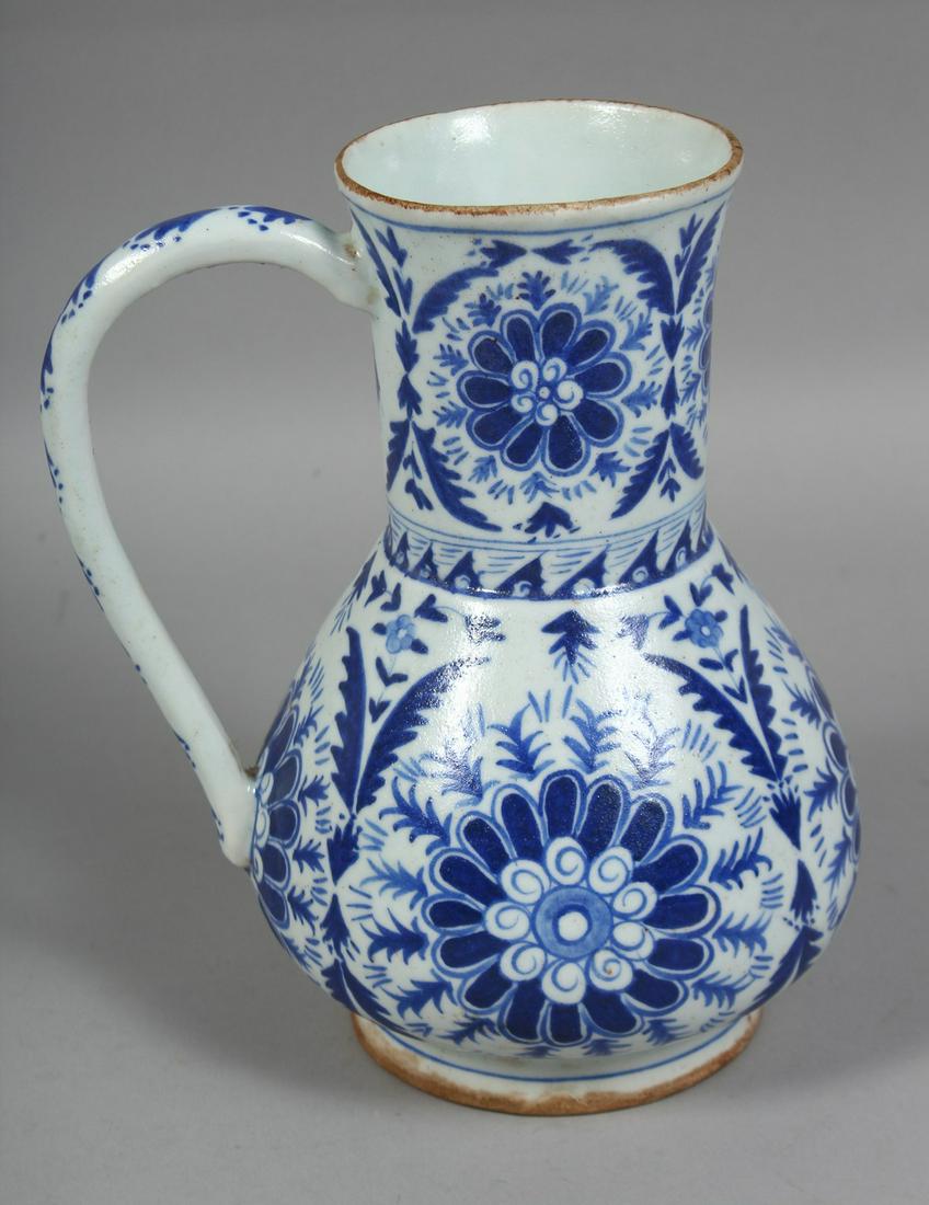 A TURKISH KUTAHYA BLUE AND WHITE GLAZED WATER JUG, painted with stylised flower heads, (AF), 22cm: A TURKISH KUTAHYA BLUE AND WHITE GLAZED WATER JUG, painted with stylised flower heads, (AF), 22cm high.