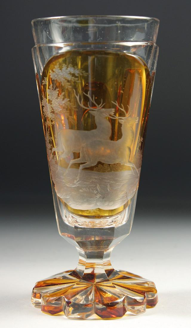 A GOOD BOHEMIAN AMBER TAPERING GLASS engraved with two stags.  6ins high. (1 of 4)