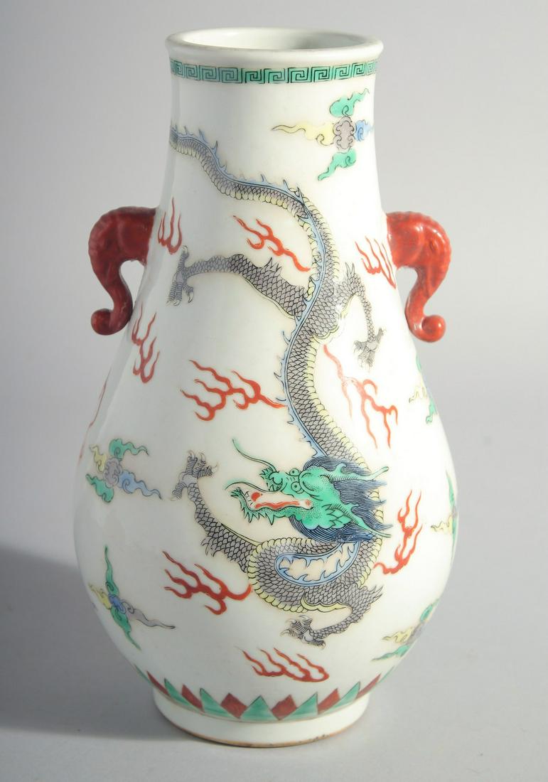A CHINESE FAMILLE ROSE DRAGON VASE with twin handles. 10ins high.: A CHINESE FAMILLE ROSE PORCELAIN DRAGON VASE with twin handles. 10ins high.