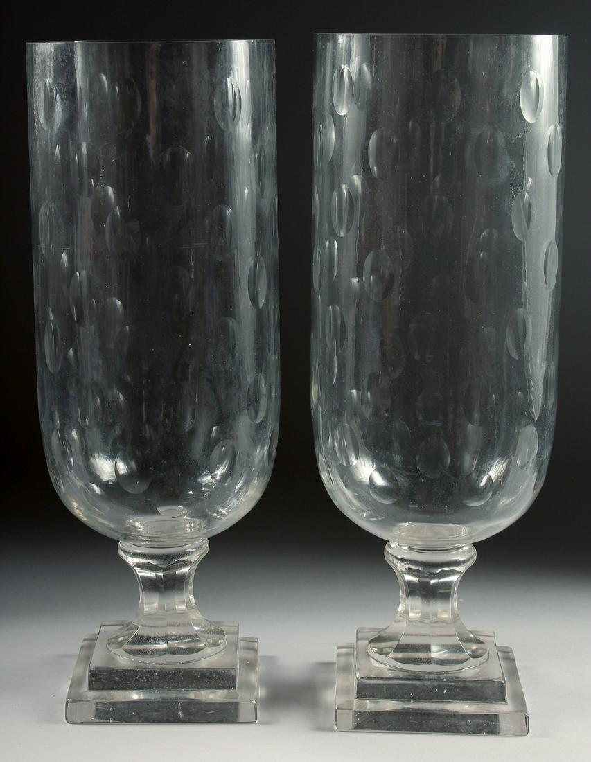 A LARGE PAIR OF GLASS STORM - HURRICANE LAMPS on square bases. 16ins high.: A LARGE PAIR OF GLASS STORM - HURRICANE LAMPS on square bases. 16ins high.