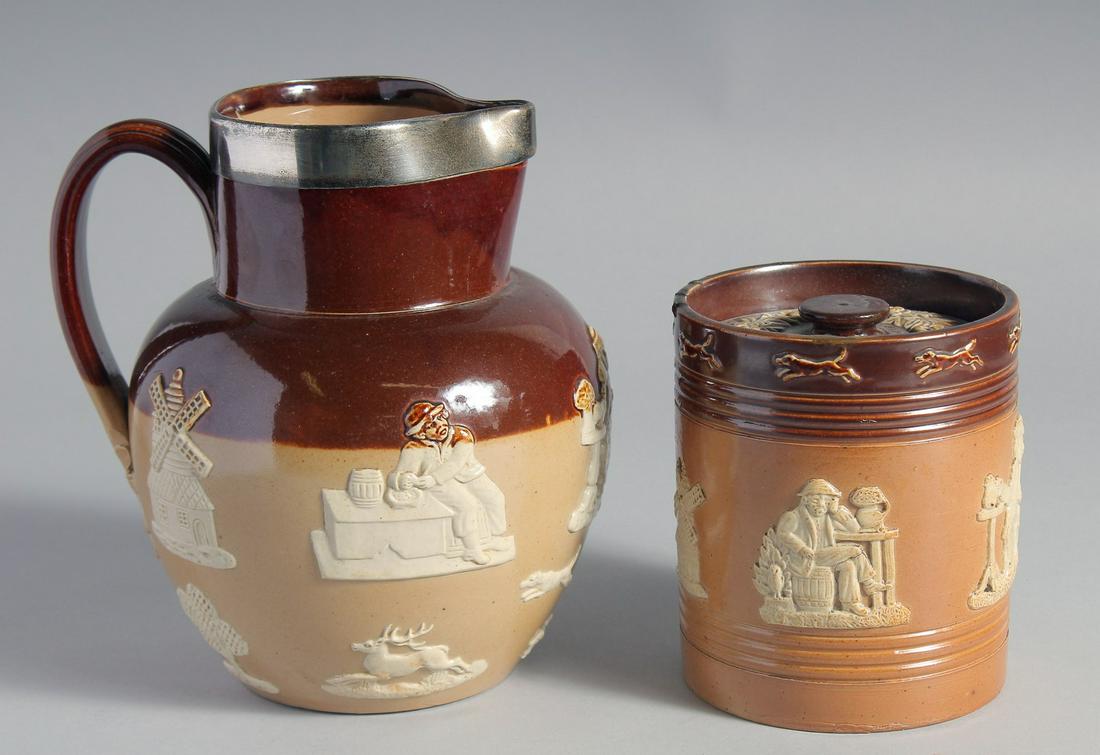 A LARGE ROYAL DOULTON STONEWARE JUG with silver band. 7.5ins high and a TOBACCO JAR AND COVER, 5ins: A LARGE ROYAL DOULTON STONEWARE JUG with silver band. 7.5ins high and a TOBACCO JAR AND COVER, 5ins high. (2).