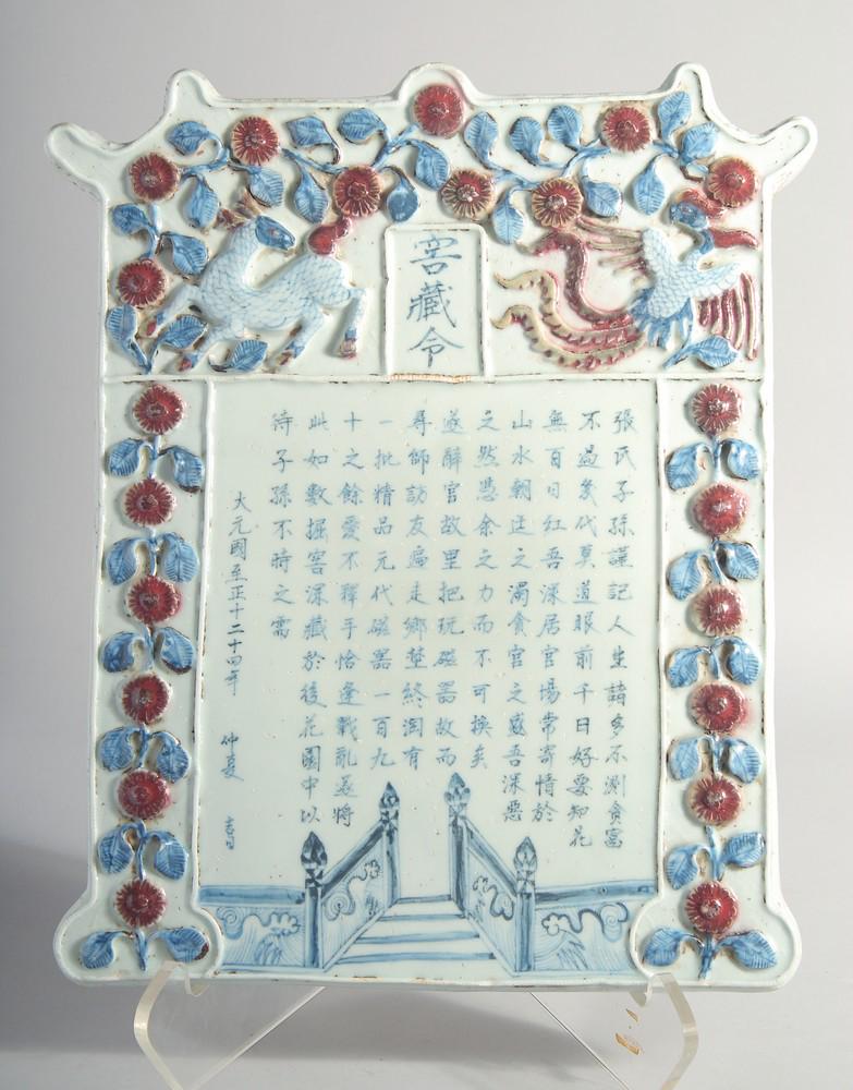 A CHINESE YUAN STYLE BLUE, WHITE AND RED GLAZED POTTERY PLAQUE, with relief decoration and: A CHINESE YUAN STYLE BLUE, WHITE AND RED GLAZED POTTERY PLAQUE, with relief decoration and inscriptions, 36cm x 29cm.