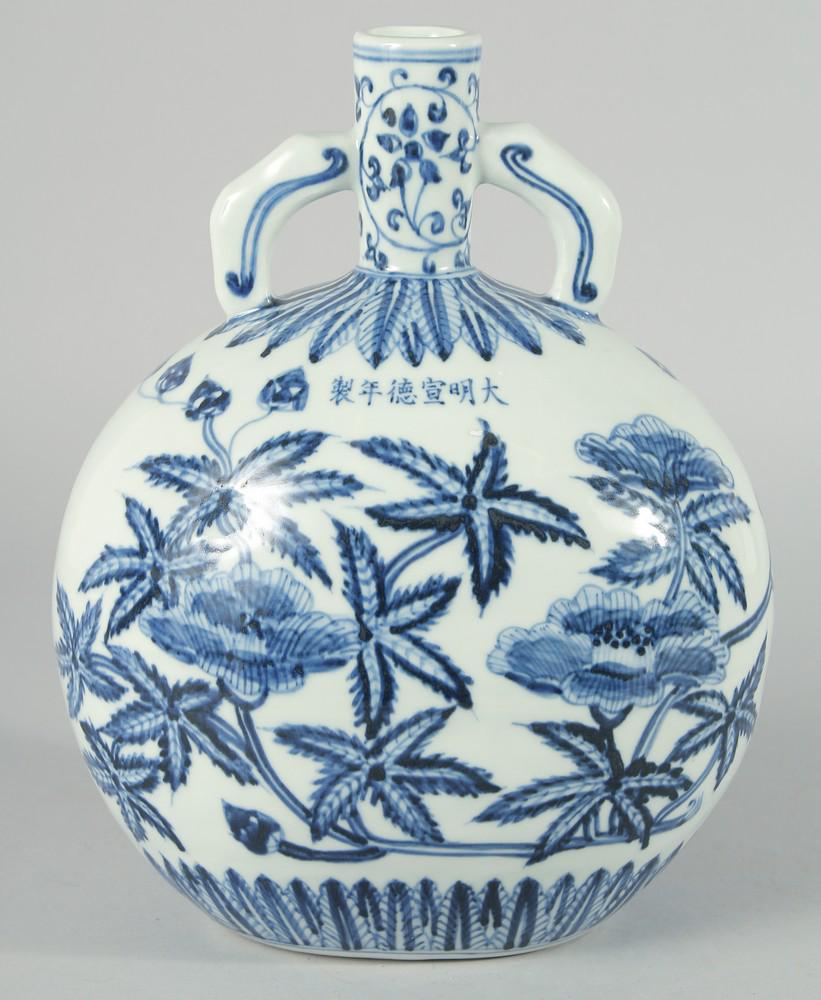 A CHINESE BLUE AND WHITE PORCELAIN TWIN HANDLE MOON FLASK, decorated with native flora, bearing: A CHINESE BLUE AND WHITE PORCELAIN TWIN HANDLE MOON FLASK, decorated with native flora, bearing six-character mark, 28cm high.