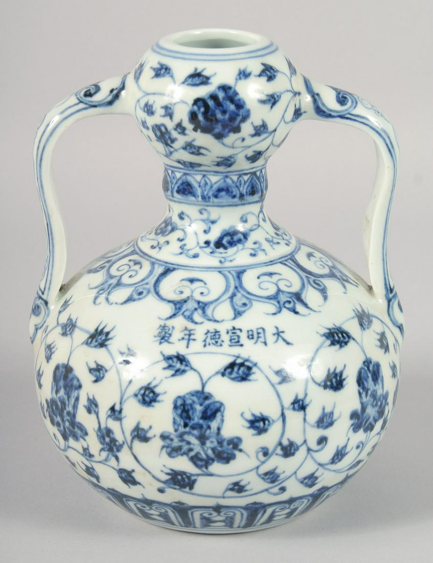 A CHINESE BLUE AND WHITE PORCELAIN GARLIC HEAD MOON FLASK, with twin handles and floral decoration,: A CHINESE BLUE AND WHITE PORCELAIN GARLIC HEAD MOON FLASK, with twin handles and floral decoration, bearing six-character mark, 20.5cm high.