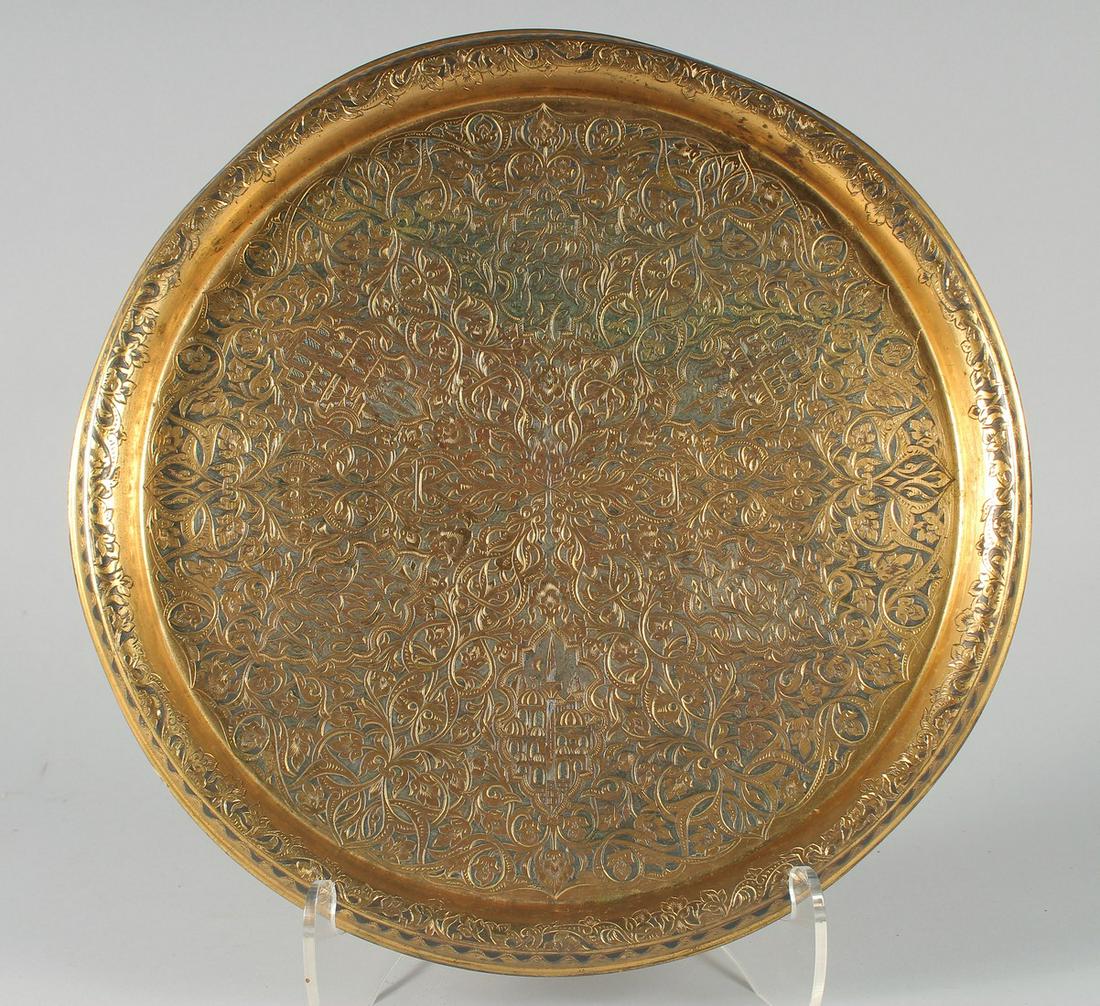 A FINE OTTOMAN TURKISH GILDED COPPER TOMBAK TRAY, with engraved calligraphy and panels of mosques,: A FINE OTTOMAN TURKISH GILDED COPPER TOMBAK TRAY, with engraved calligraphy and panels of mosques, 34cm diameter.