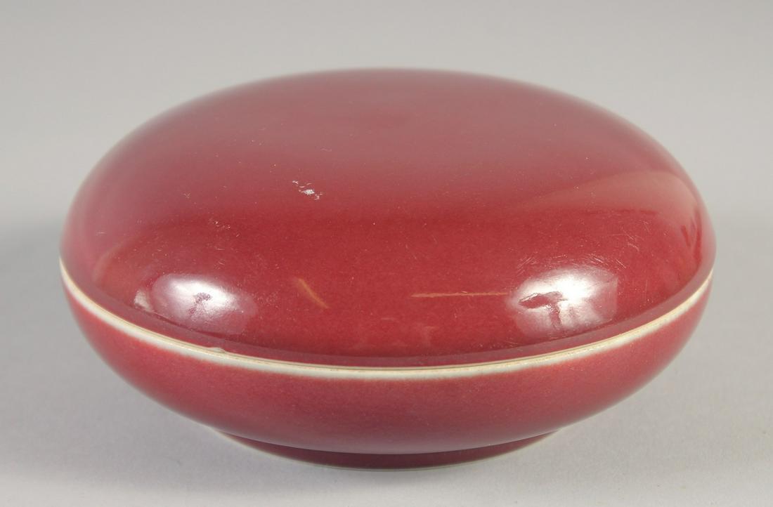 A CHINESE COPPER RED PORCELAIN CIRCULAR BOX AND COVER, six-character mark to base, 14.5cm diameter. (1 of 5)
