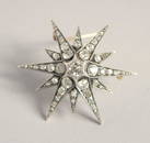 A GOOD VICTORIAN DIAMOND SET STAR BROOCH with central diamond, six medium diamonds and smaller