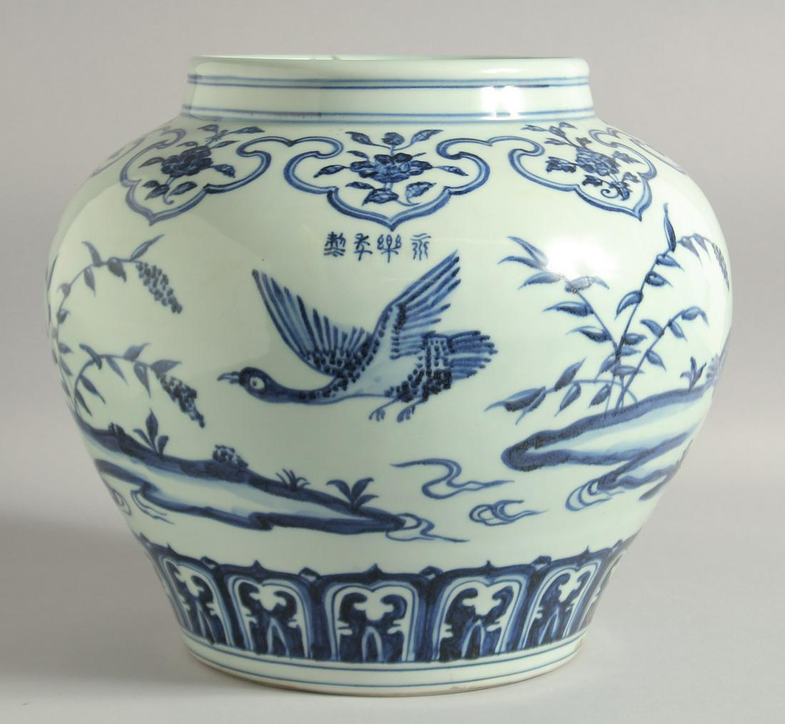 A LARGE CHINESE BLUE AND WHITE PORCELAIN JARDINIERE, painted with birds and flora, bearing a: A LARGE CHINESE BLUE AND WHITE PORCELAIN JARDINIERE, painted with birds and flora, bearing a four-character mark to shoulder, 29cm high.