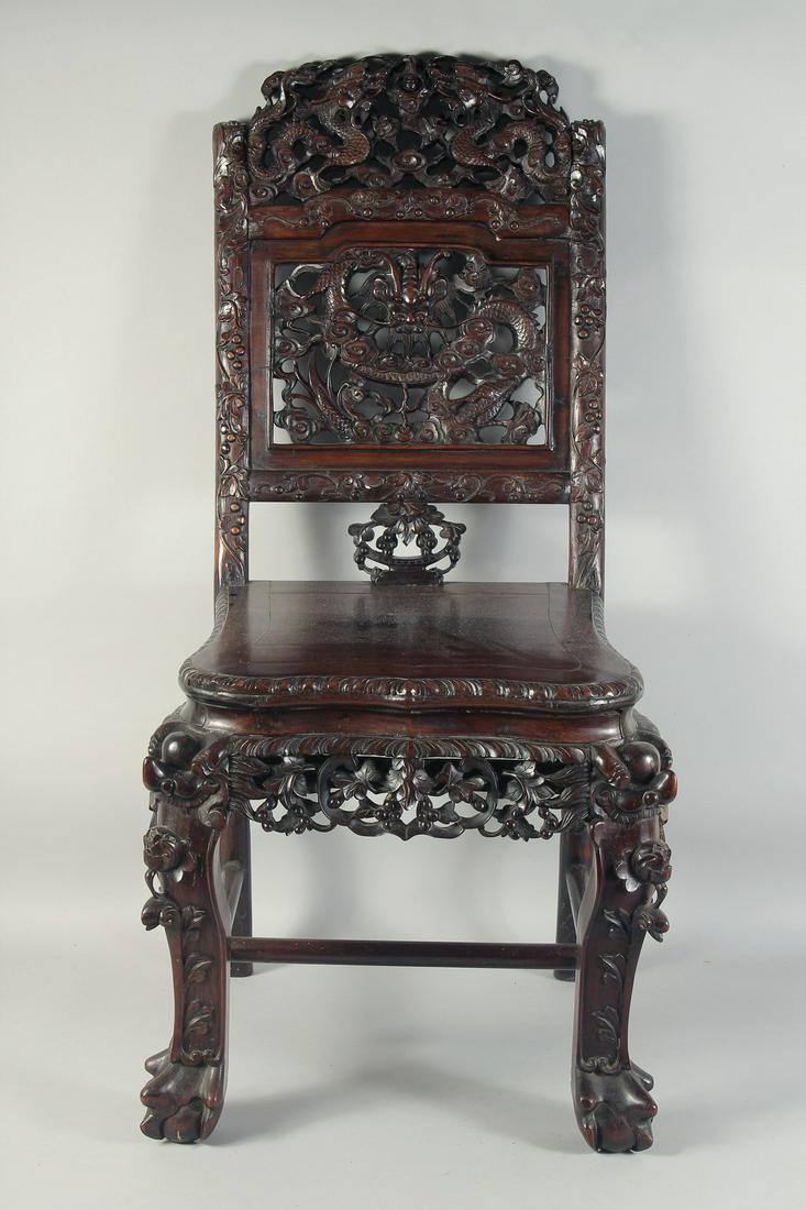 A 19TH CENTURY CHINESE CARVED HARDWOOD CHAIR, the back rest carved and pierced with dragons and: A 19TH CENTURY CHINESE CARVED HARDWOOD CHAIR, the back rest carved and pierced with dragons and stylised clouds, the seat with further carved and pierced foliate apron; with similarly carved legs unit