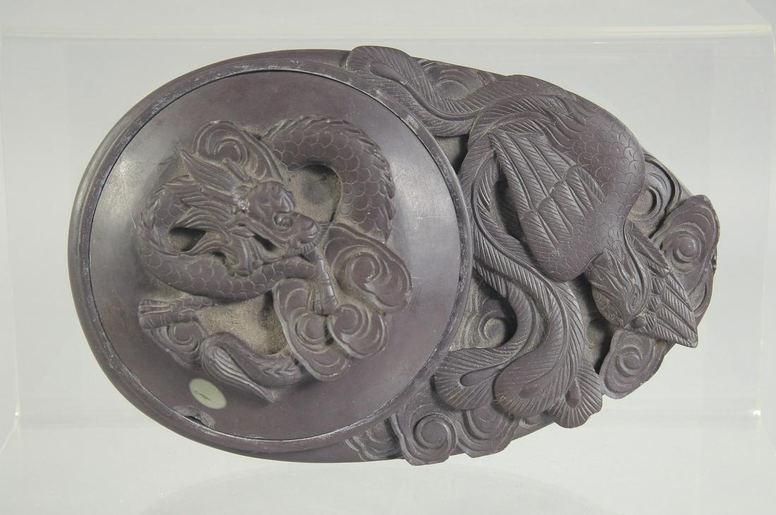 A 19TH CENTURY CHINESE CARVED INKSTONE CALLIGRAPHY INKWELL, carved with dragon and phoenix, 16.5cm x: A 19TH CENTURY CHINESE CARVED INKSTONE CALLIGRAPHY INKWELL, carved with dragon and phoenix, 16.5cm x 10.5cm.