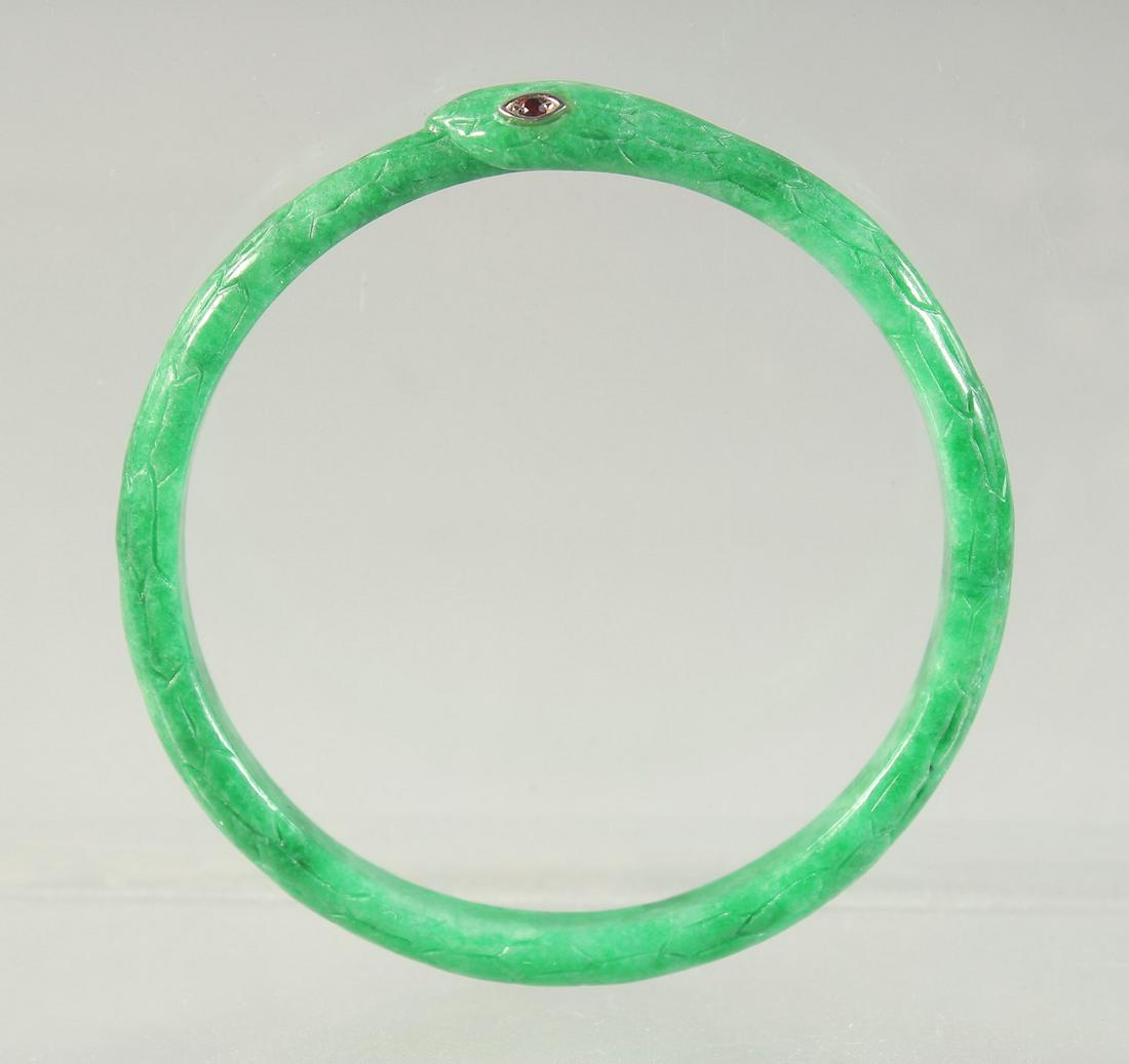A JADEITE SNAKE-FORM BRACELET with inset ruby eyes, 7cm diameter.: A JADEITE SNAKE-FORM BRACELET with inset ruby eyes, 7cm diameter.