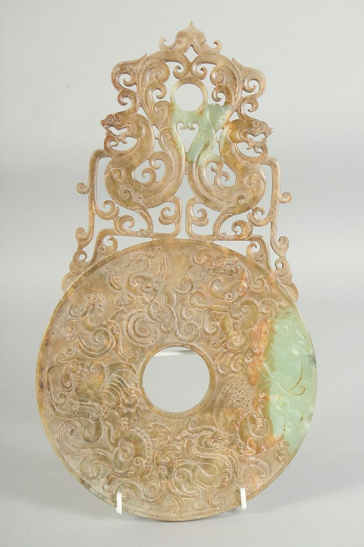 A SUPERB LARGE JADE DISK, with relief and pierced decoration depicting dragons, 34.5cm x 19.5cm.: A SUPERB LARGE JADE DISK, with relief and pierced decoration depicting dragons, 34.5cm x 19.5cm.