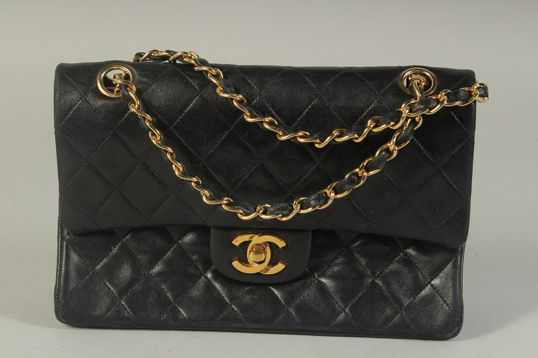 A CHANEL BLACK PADDED LEATHER BAG, 8ins long with entwined gilt and leather chain, 14ins long. (1 of 5)