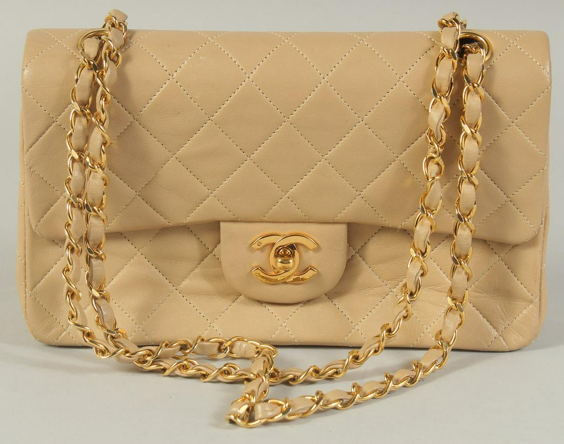 A CHANEL PADDED CREAM LEATHER HANDBAG with entwined leather and gilt strap, 9.5in wide. (1 of 4)