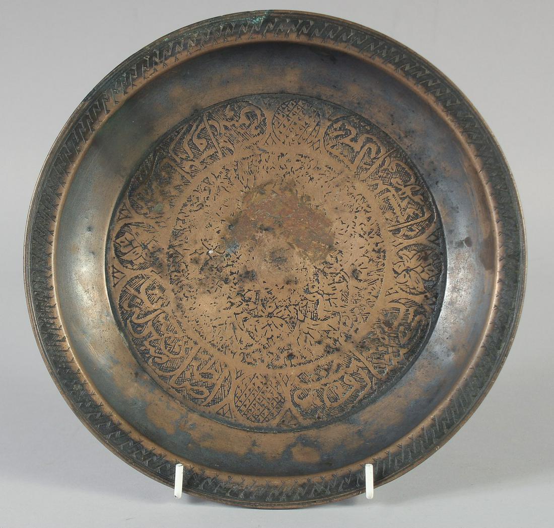 A 15TH CENTURY PERSIAN TIMURID ENGRAVED COPPER DISH, with panels of calligraphy, 23.5cm diameter. (1 of 2)