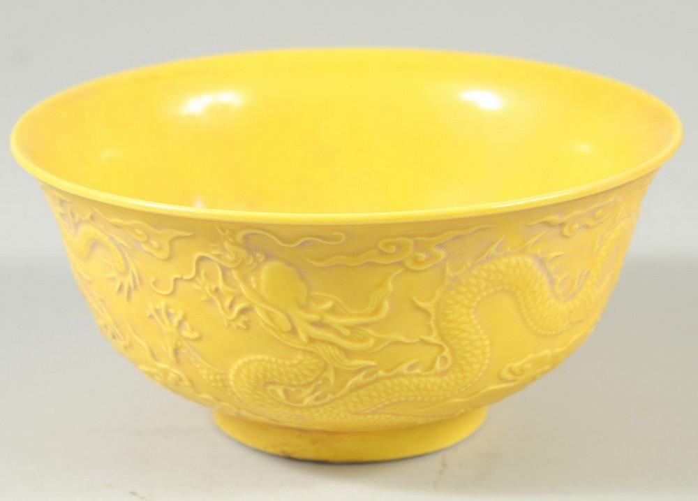 A CHINESE YELLOW GROUND CIRCULAR BOWL with dragons in relief. Mark in blue. 6ins diameter.: A CHINESE YELLOW GROUND CIRCULAR BOWL with dragons in relief. Mark in blue. 6ins diameter.