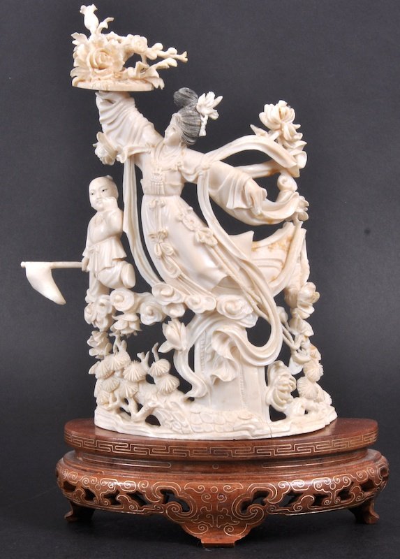 AN EARLY 20TH CENTURY CHINESE CANTON IVORY FIGURAL : AN EARLY 20TH CENTURY CHINESE CANTON IVORY FIGURAL GROUP depicting a mother and child leaping amongst foliage, upon an inlaid hardwood base. 7. 5ins high.