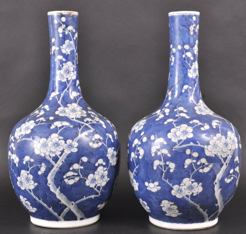A PAIR OF EARLY 19TH CENTURY CHINESE BLUE AND WHIT: A PAIR OF EARLY 19TH CENTURY CHINESE BLUE AND WHITE VASES bearing Kangxi mark to base, painted with almond blossom. One repaired. 13. 5ins high.