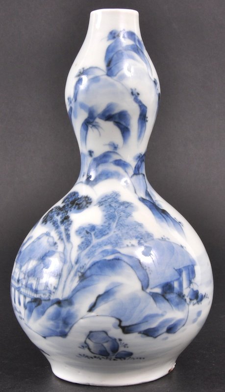 A 19TH CENTURY JAPANESE BLUE AND WHITE GOURD VASE: A 19TH CENTURY JAPANESE BLUE AND WHITE GOURD VASE painted with landscapes and buildings. Signed. Good condition, firing flaw to footrim. 6. 5ins high.