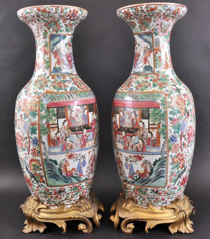 A GOOD PAIR OF 19TH CENTURY CHINESE FAMILLE ROSE: A GOOD PAIR OF 19TH CENTURY CHINESE FAMILLE ROSE VASES painted with panels of scholars seated within interiors, the bodies decorated with birds, insects and foliage, supported on upon French ormolu ro