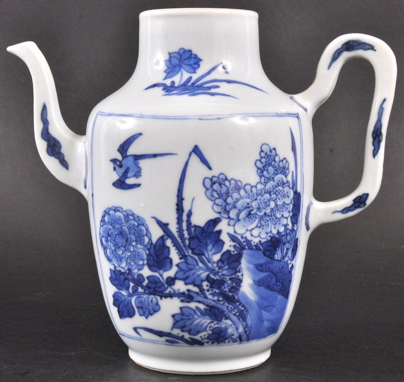 A CHINESE KANGXI PORCELAIN BLUE AND WHITE TEAPOT C: A CHINESE KANGXI PORCELAIN BLUE AND WHITE TEAPOT C1710 painted with square panels of flowering rock and floral sprays. Possibly minor restoration. 6. 5ins high.
