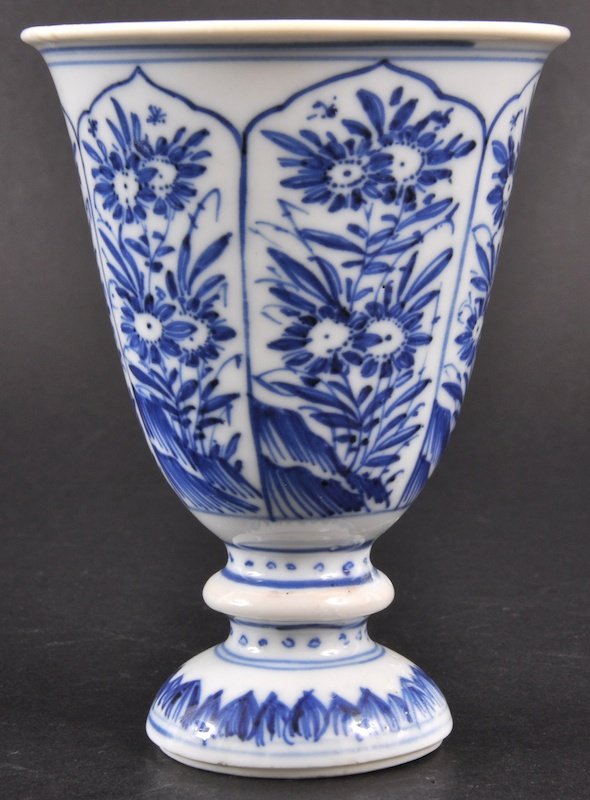 A CHINESE KANGXI PORCELAIN BLUE AND WHITE STEM CU: A CHINESE KANGXI PORCELAIN BLUE AND WHITE STEM CUP C1710 painted with panels of foliage. Hairline, stem repair. 4. 5ins high.