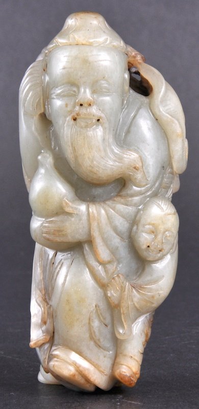 A CHINESE GREEN CELADON RUSSET JADE FIGURE OF SAG: A CHINESE GREEN CELADON RUSSET JADE FIGURE OF SAGE modelled with a young attendant by his side, holding a double gourd. Good condition. 3. 75ins high. Provenance: Acquired in China by the vendors Moth