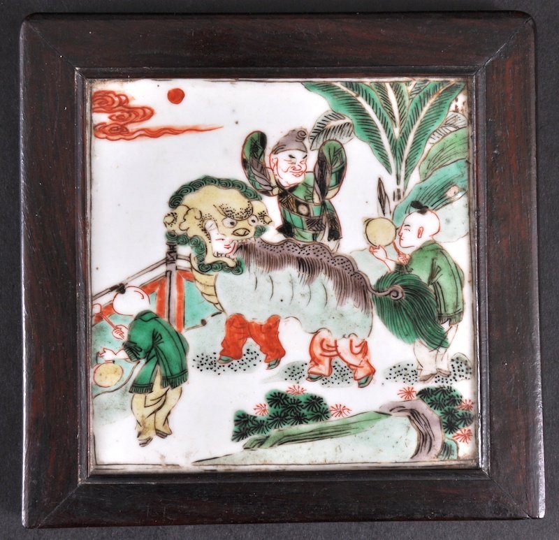 A CHINESE KANGXI FAMILLE VERTE SQUARE TILE C1700 : A CHINESE KANGXI FAMILLE VERTE SQUARE TILE C1700 contained with Zitan wood frame, painted with figures and a shi shi dog. Good condition. 5. 5ins square.