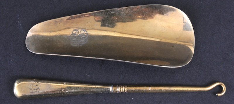 A CARTIER METAL SHOE HORN AND BUTTON HOOK (2).: A CARTIER METAL SHOE HORN AND BUTTON HOOK (2).