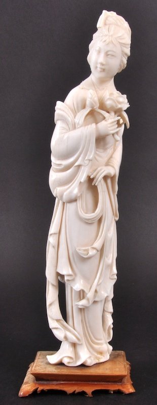 A CHINESE CARVED IVORY FIGURE OF A YOUNG GIRL holdi: A CHINESE CARVED IVORY FIGURE OF A YOUNG GIRL holding a rose. 9. 5ins high.