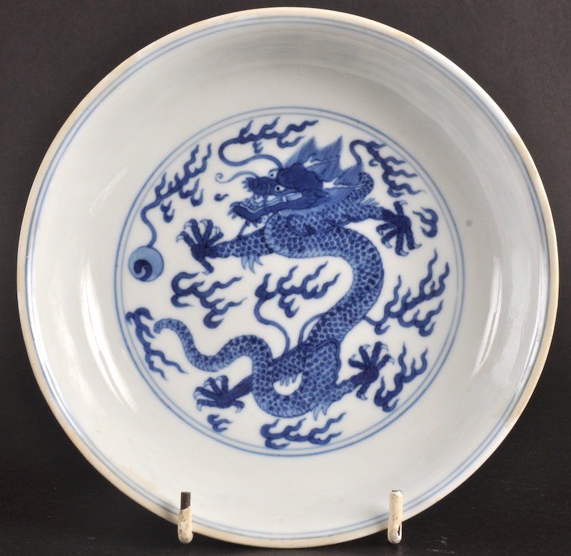 AN 18TH CENTURY CHINESE BLUE AND WHITE CIRCULAR D: AN 18TH CENTURY CHINESE BLUE AND WHITE CIRCULAR DISH Qianlong mark and period, painted with a dragon pursuing a flaming pearl. Minor rim restoration.6.5ins diameter. Provenance: Orientique, Hong Kong.