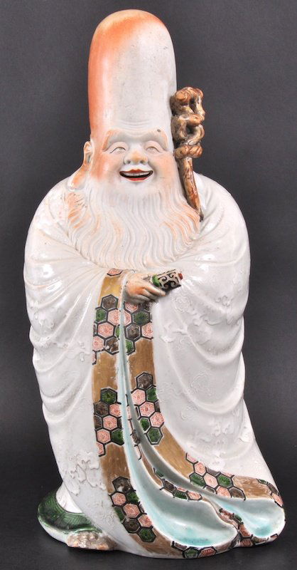 A RARE LATE 19TH CENTURY JAPANESE PORCELAIN FIGUR: A RARE LATE 19TH CENTURY JAPANESE PORCELAIN FIGURE OF FUKUROKUJU unusually modelled in robes enamelled with clouds, painted with gilt motifs, holding a scroll. Nicks to feet, tiny repair to scroll.17.