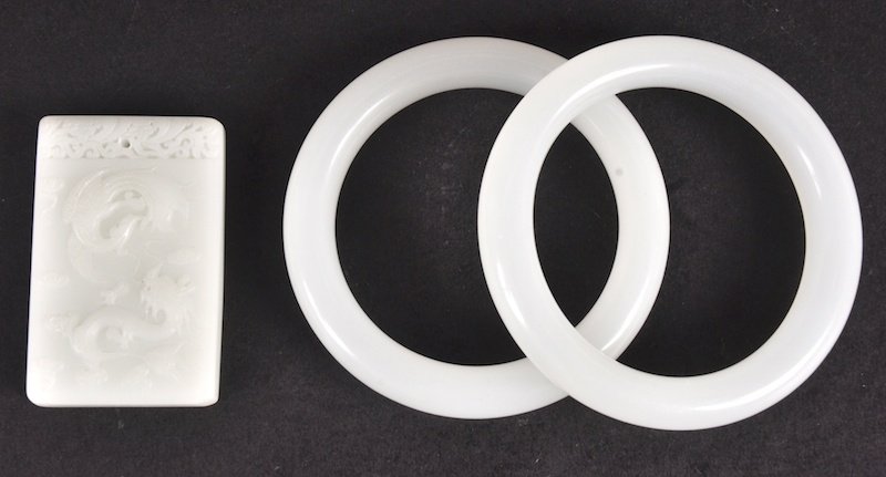 A PAIR OF CHINESE WHITE JADE CIRCULAR BANGLES toget: A PAIR OF CHINESE WHITE JADE CIRCULAR BANGLES together with a white jade plaque. Good condition. (3)