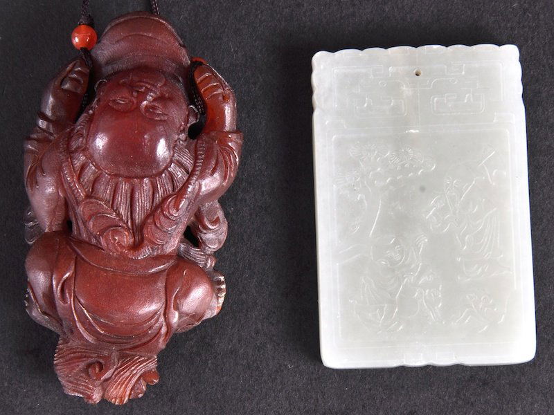 A CHINESE GREEN JADE SQUARE PLAQUE carved with a: A CHINESE GREEN JADE SQUARE PLAQUE carved with a child and scholar, together with a carved buffalo horn pendant. Good condition. (2)