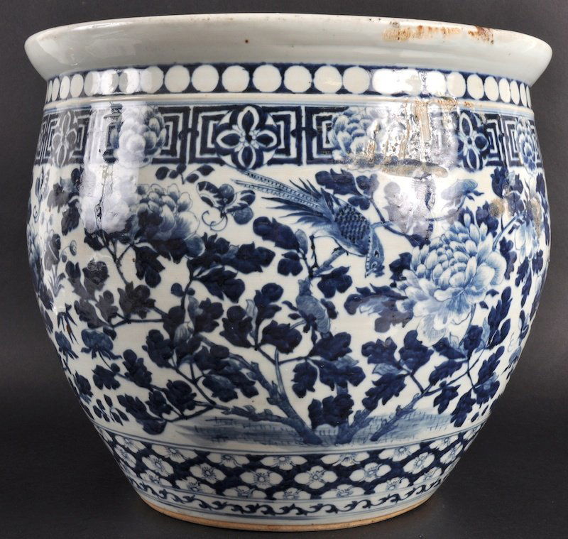 A 19TH CENTURY CHINESE BLUE AND WHITE FISH BOWL pa: A 19TH CENTURY CHINESE BLUE AND WHITE FISH BOWL painted with bold floral sprays under a border of circular motifs. Star crack to body.15.75ins diameter.