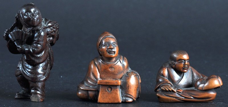 AN EARLY 20TH CENTURY JAPANESE MEIJI PERIOD BOXW: AN EARLY 20TH CENTURY JAPANESE MEIJI PERIOD BOXWOOD NETSUKE modelled as a mask maker, together with two other netsukes. Two signed. Good condition. (3)