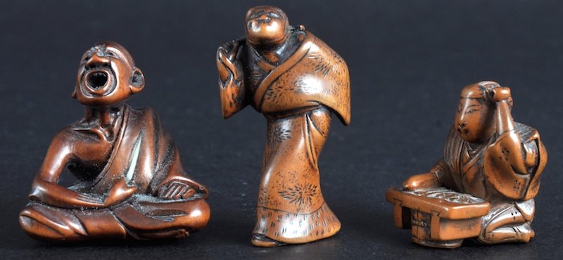 AN EARLY 20TH CENTURY JAPANESE MEIJI PERIOD BOXW: AN EARLY 20TH CENTURY JAPANESE MEIJI PERIOD BOXWOOD NETSUKE modelled as a man tickling himself with grass, together with two other netsukes. Two signed. Good condition. (3)