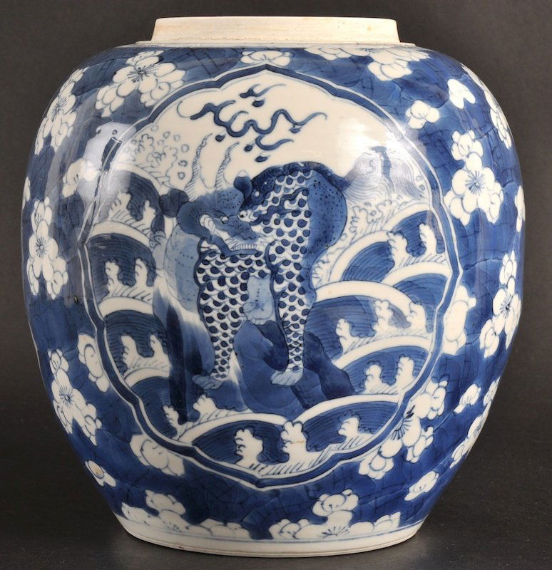 A CHINESE KANGXI PORCELAIN BLUE AND WHITE GINGER: A CHINESE KANGXI PORCELAIN BLUE AND WHITE GINGER JAR C1700 the front painted with a lion standing amongst crashing waves, the reverse a fish. Minor fritting.7.75ins wide.