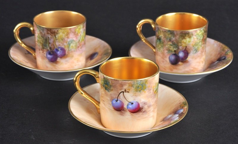 A PAIR OF ROYAL WORCESTER CABINET CUPS BY FREEMAN: A PAIR OF ROYAL WORCESTER CABINET CUPS BY FREEMAN painted with fruit, together with another Worcester cup and saucer. Good condition. (3)