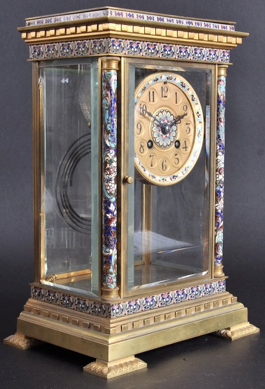 A 19TH CENTURY FRENCH CHAMPLEVE ENAMEL BRASS MANT: A 19TH CENTURY FRENCH CHAMPLEVE ENAMEL BRASS MANTLE CLOCK decorated to each column and the dial with foliage and scrolling flowers. 12ins high.